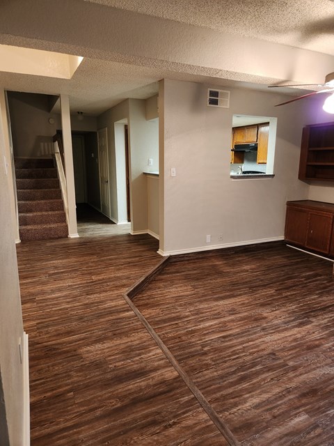 an empty living room with a hardwood floor